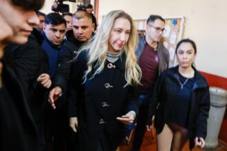 Votó rodeada por un escudo de militantes, casi sin emitir palabra y con una inédita caminata hasta el auto
